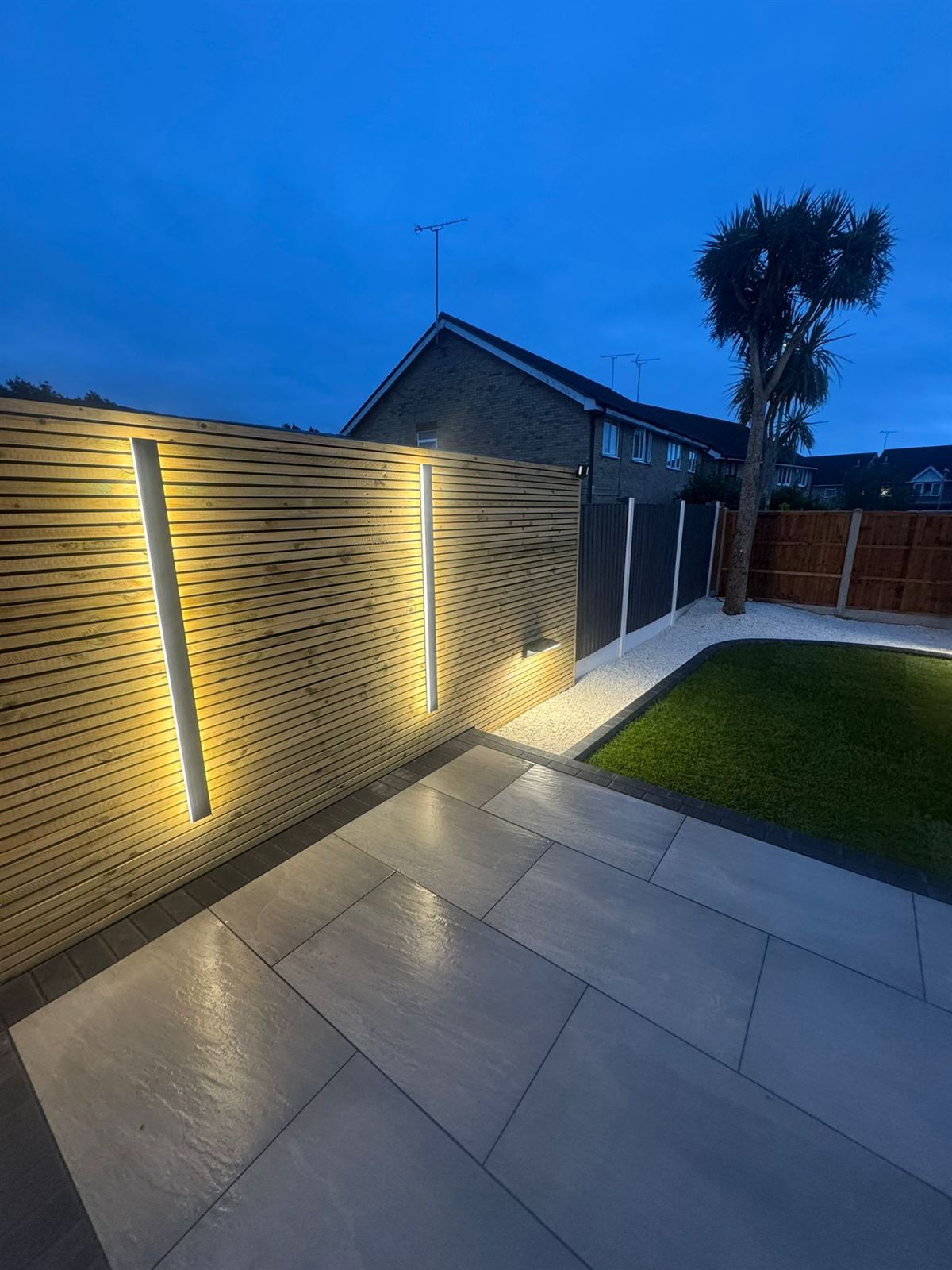 Porcelain patio with uplit fence and garden landscaping completed by Purdy's Paving